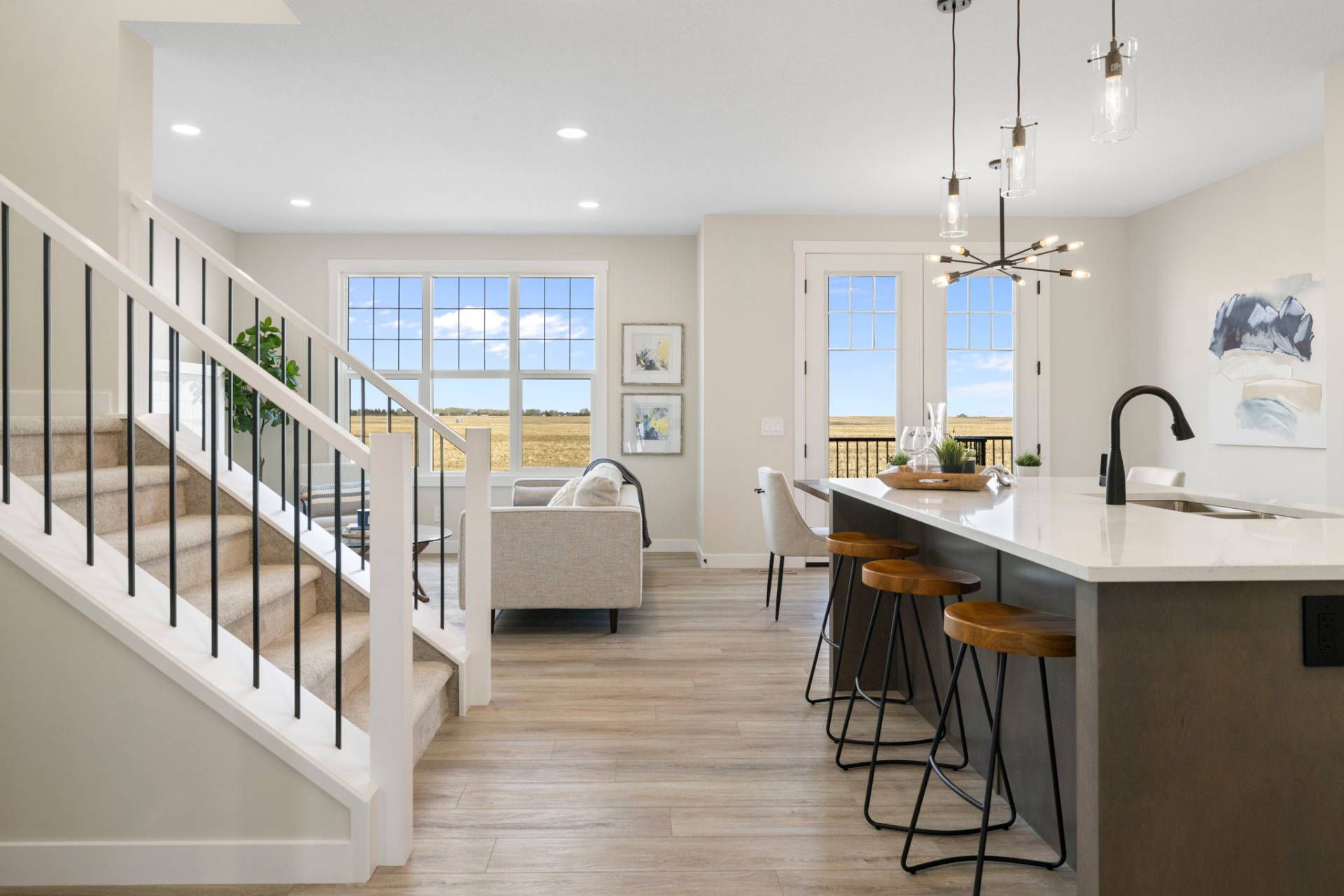 Bright open-concept kitchen and staircase in a Golden Homes show home